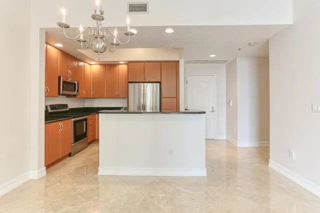 a kitchen with stainless steel appliances granite countertop a refrigerator a sink and a stove