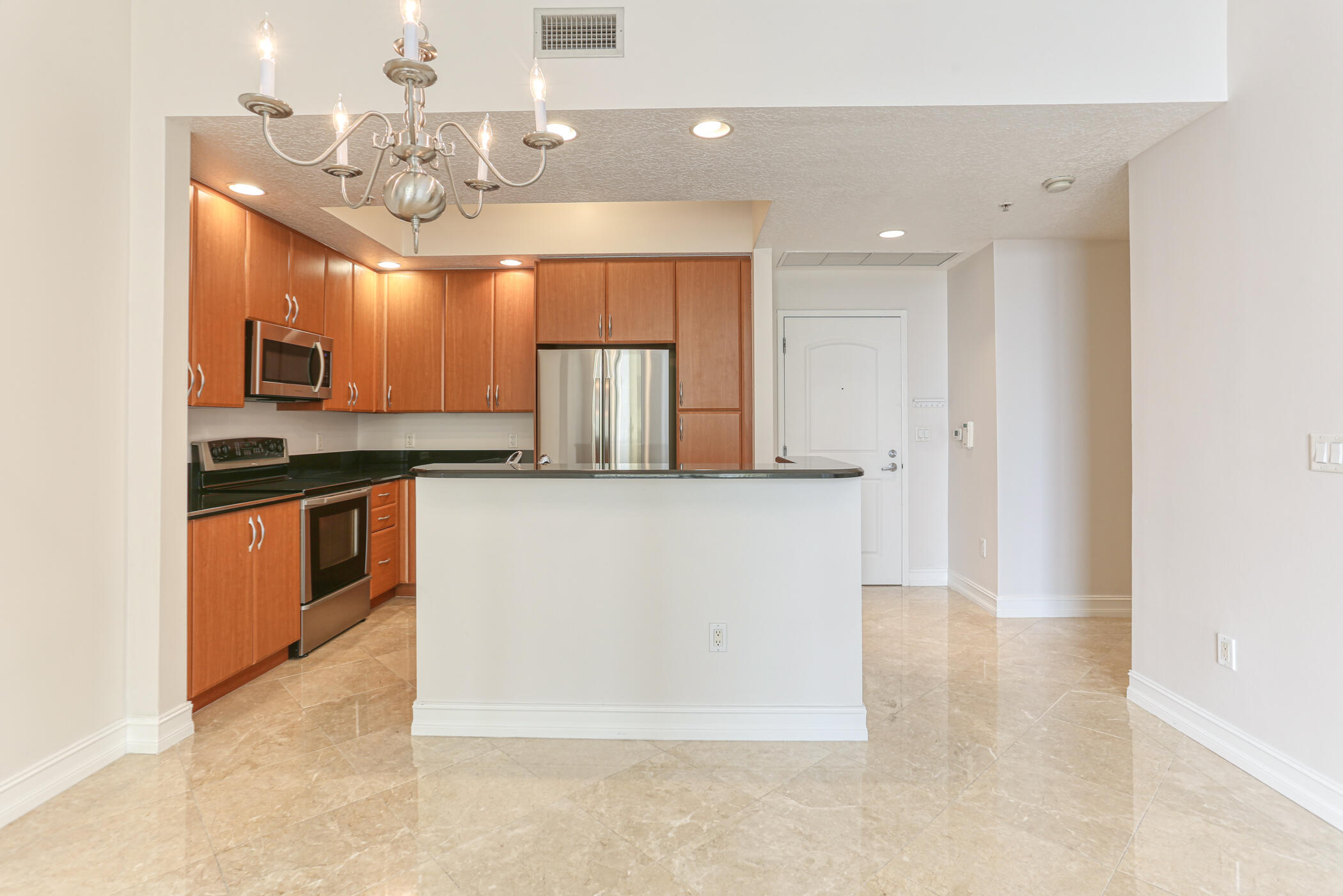 701 South Olive Avenue, Unit 603 West Palm Beach, FL 33401 - Photo 7 of 23 a kitchen with kitchen island granite countertop stainless steel appliances cabinets a sink and a counter top