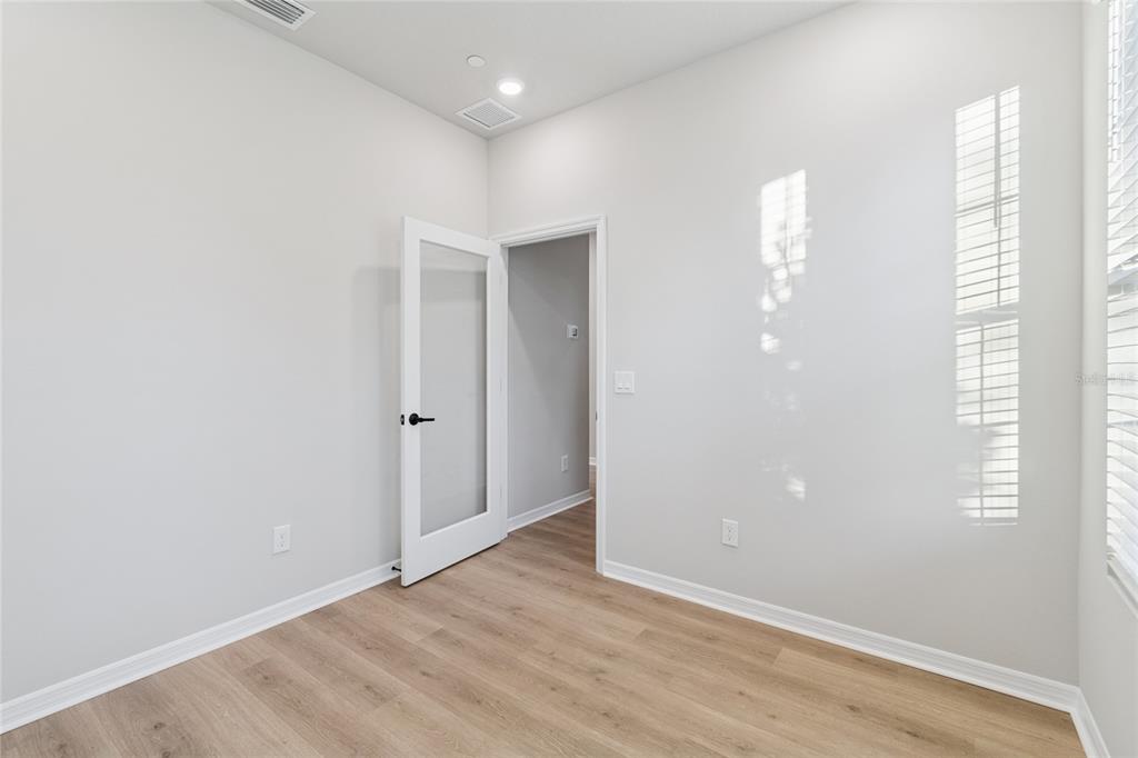 4317 Roush Avenue Orlando, FL 32803 - Photo 13 of 39 an empty room with wooden floor and windows