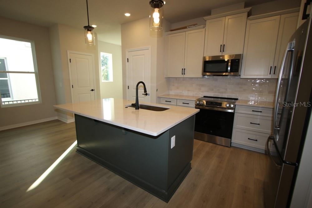 4317 Roush Avenue Orlando, FL 32803 - Photo 7 of 13 a kitchen with stainless steel appliances granite countertop a sink a stove and a refrigerator