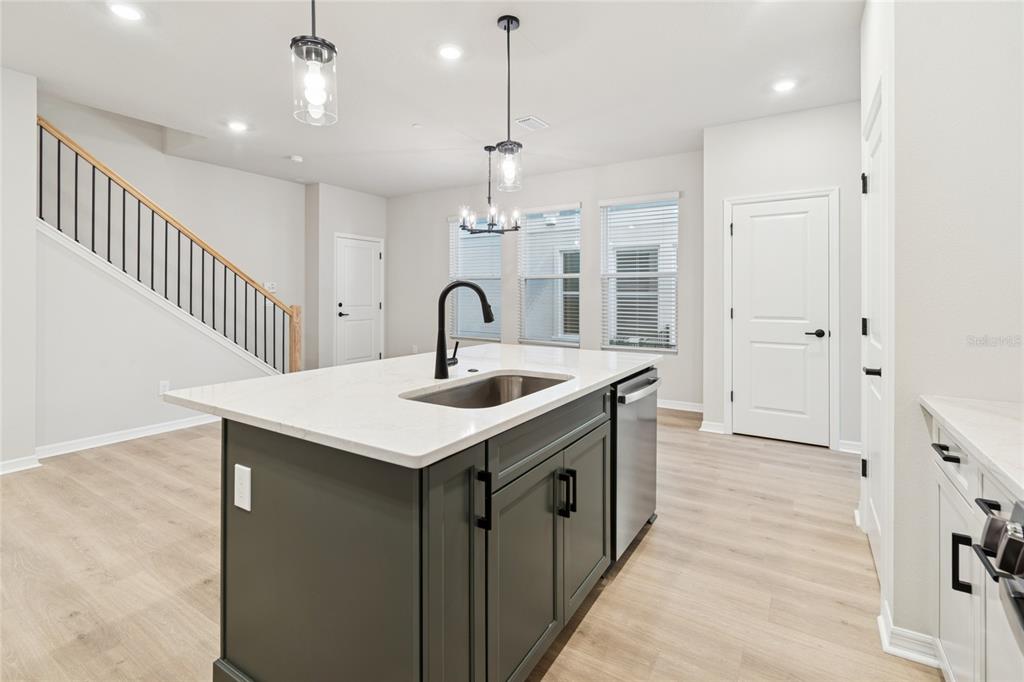 4317 Roush Avenue Orlando, FL 32803 - Photo 7 of 39 a kitchen with a sink a chandelier stainless steel appliances and cabinets