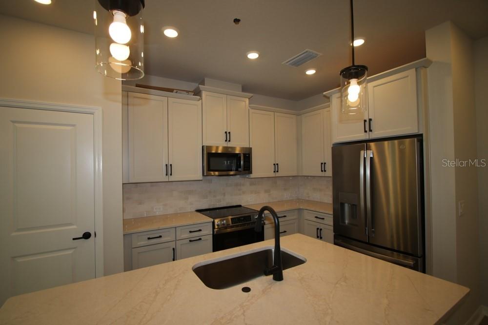 4317 Roush Avenue Orlando, FL 32803 - Photo 8 of 13 a kitchen with kitchen island a sink stainless steel appliances and cabinets
