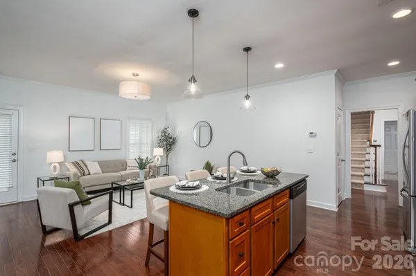 a kitchen with granite countertop a sink cabinets and wooden floor