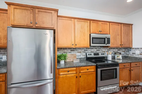a kitchen with stainless steel appliances granite countertop a refrigerator stove microwave and sink