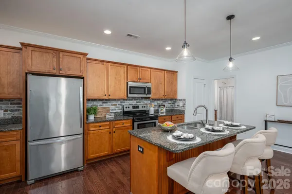 a kitchen with a refrigerator a stove a sink and a center island