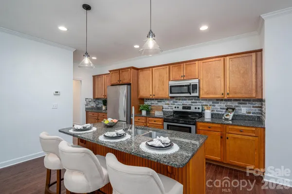 a kitchen with a sink a stove and chairs