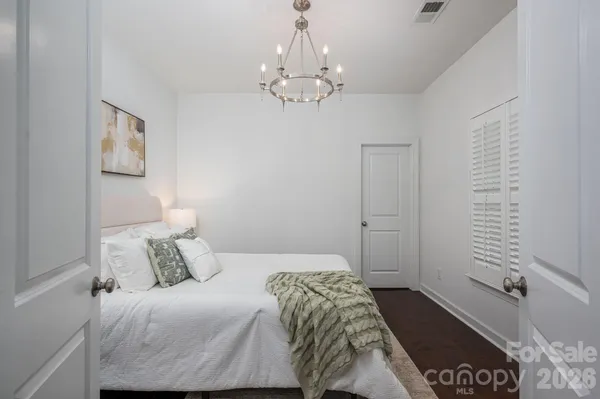 a bedroom with a bed and a chandelier