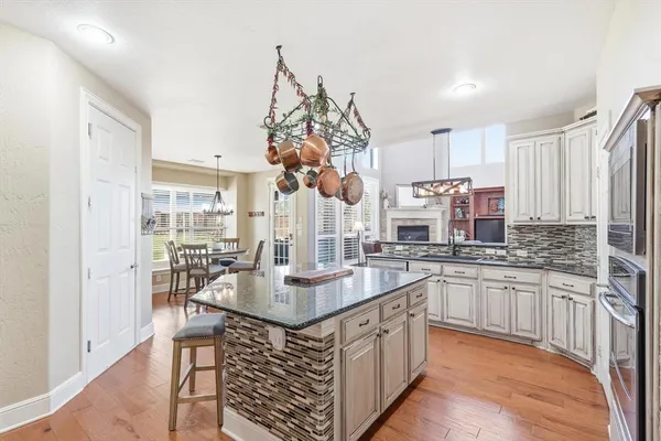 a kitchen with stainless steel appliances granite countertop a sink a stove and a refrigerator