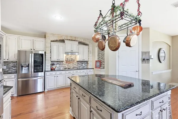 a kitchen with stainless steel appliances granite countertop a sink a stove and refrigerator