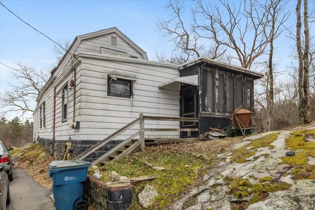a view of wooden house with a large tree and wooden fence