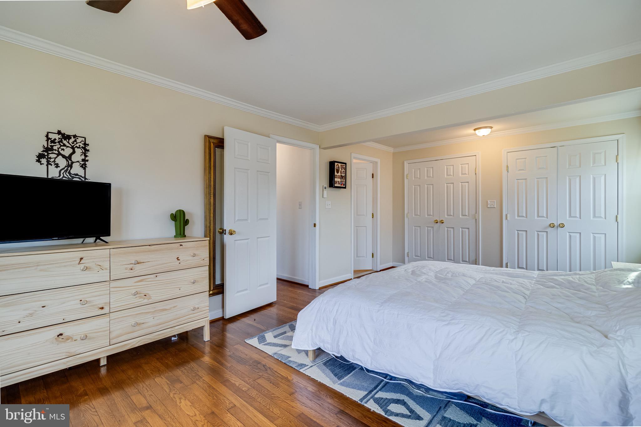 6905 East Clinton Street Clinton, MD 20735 - Photo 26 of 47 a spacious bedroom with a bed and a flat screen tv