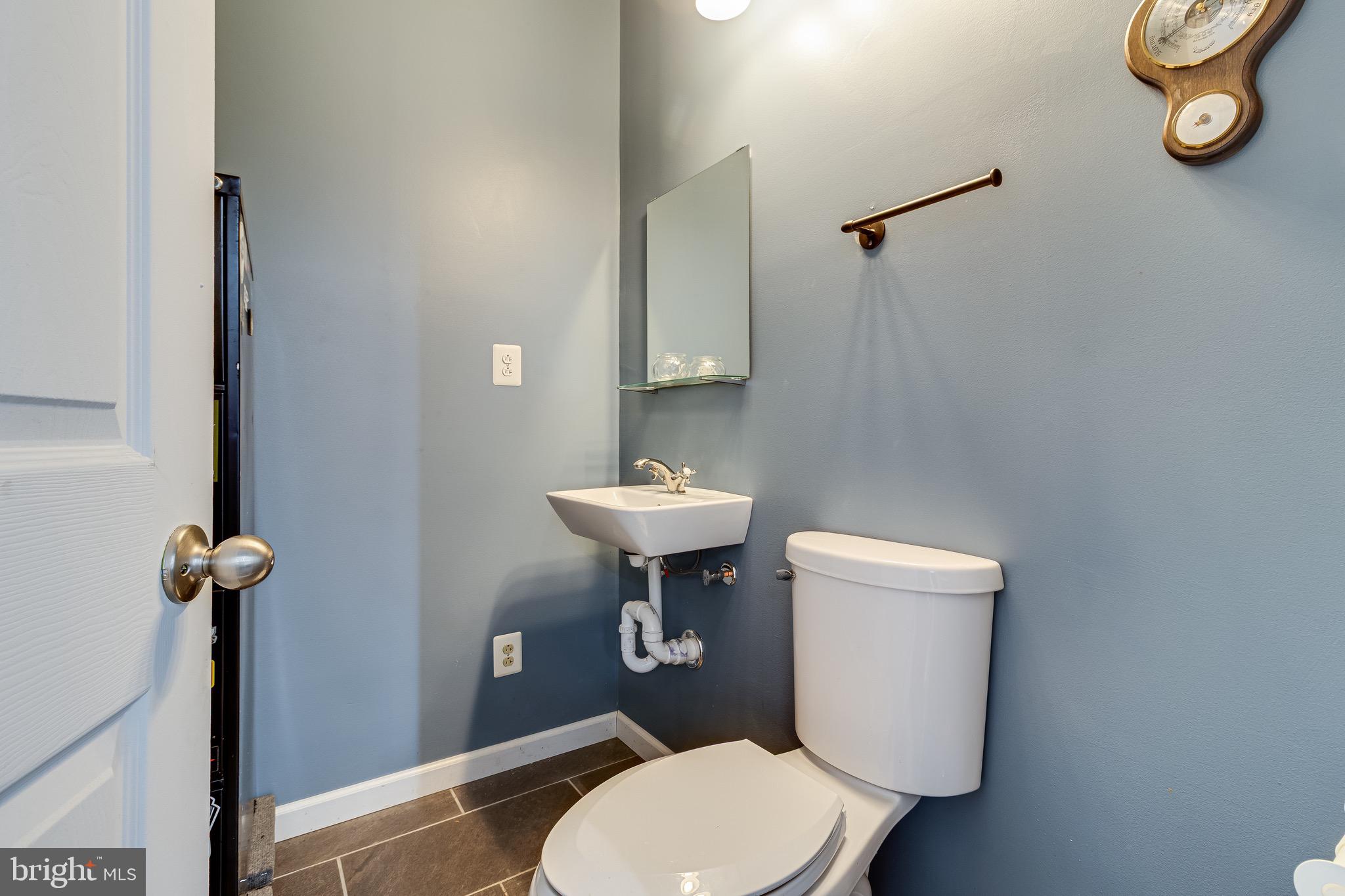 6905 East Clinton Street Clinton, MD 20735 - Photo 37 of 47 a bathroom with a toilet a sink and a mirror