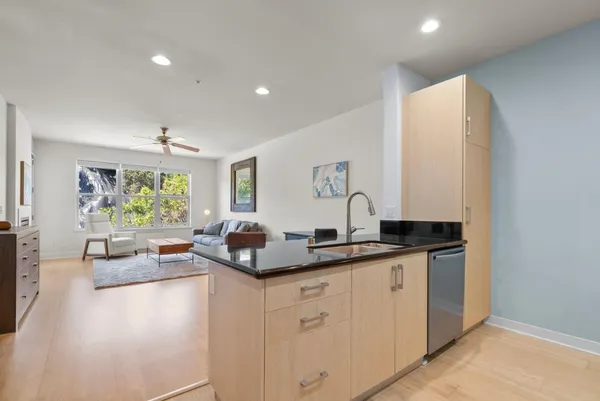 a kitchen with counter top space sink and living room