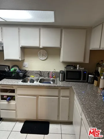 a kitchen with a sink a refrigerator and cabinets