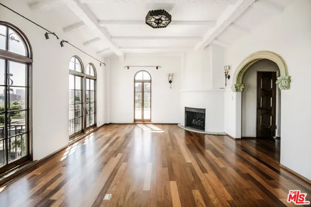 a view of empty room with wooden floor and fireplace