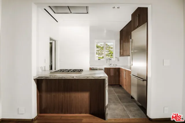 a kitchen with stainless steel appliances granite countertop a refrigerator and a stove