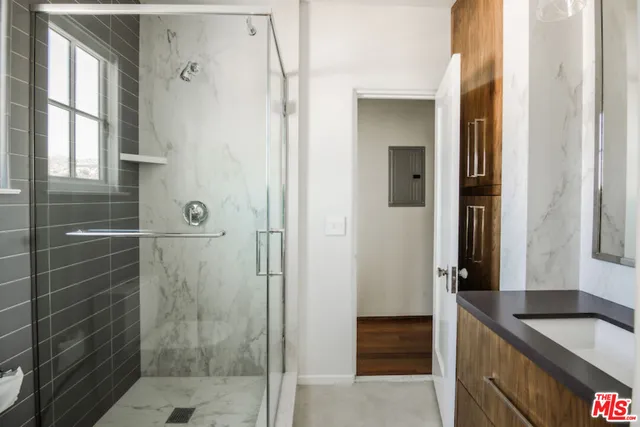 a bathroom with a granite countertop shower mirror and a sink