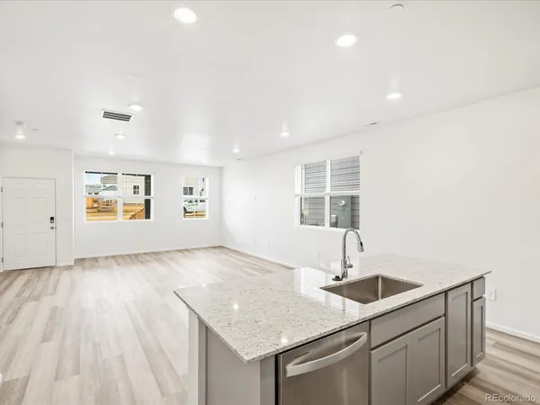 a kitchen with a sink cabinets and wooden floor