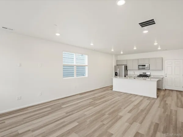 a view of kitchen with kitchen island white cabinets and wooden floor