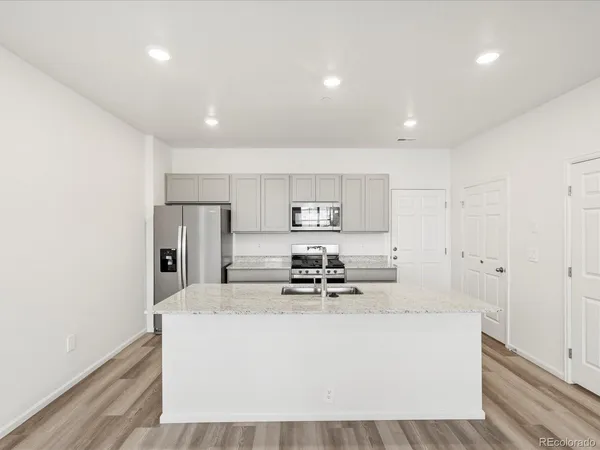a view of kitchen with stainless steel appliances refrigerator stove microwave and cabinets