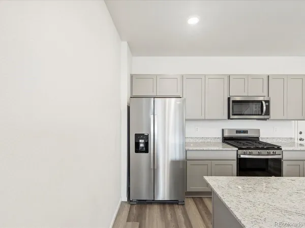 a kitchen with stainless steel appliances a refrigerator and a stove top oven