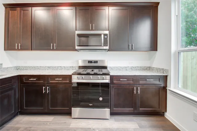 a kitchen with stainless steel appliances granite countertop a stove and a microwave oven