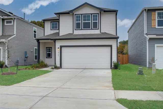 a front view of a house with a yard and garage
