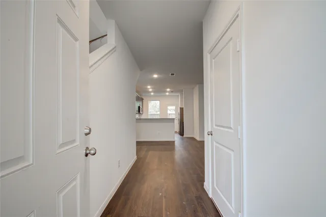 a view of a hallway with wooden floor