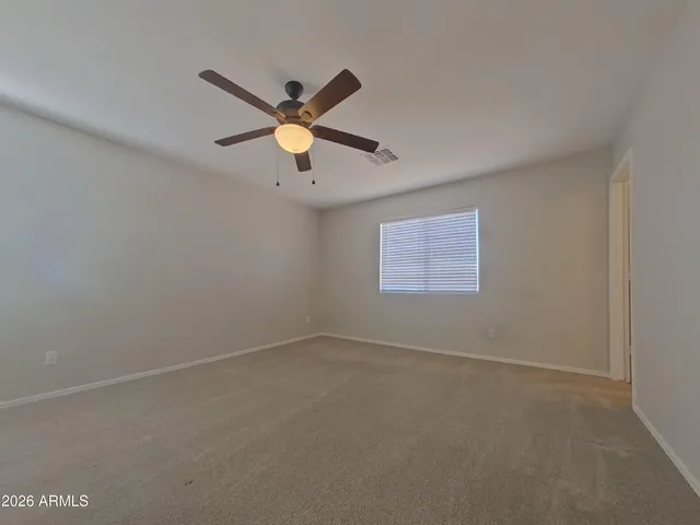 an empty room with a window and a fan