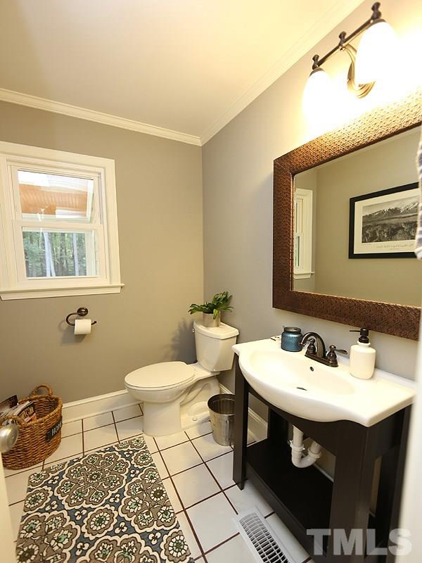 8320 Wheatstone Lane Raleigh, NC 27613 - Photo 12 of 23 Cute 1/2 Bathroom is cleaverly tucked between the Kitchen and the Living Room, across from an oversized storage closet.