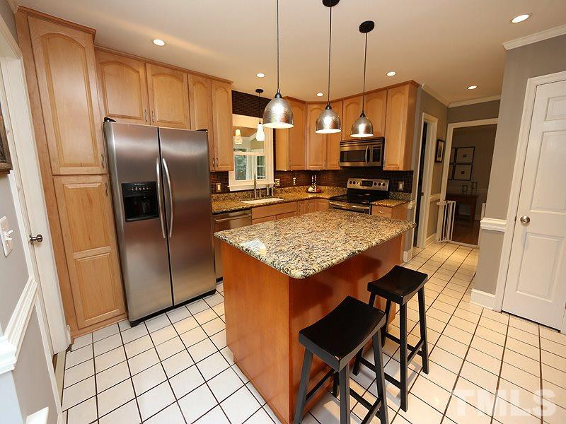 8320 Wheatstone Lane Raleigh, NC 27613 - Photo 7 of 23 Remodeled kitchen features granite, wood cabinets & SS appliances.