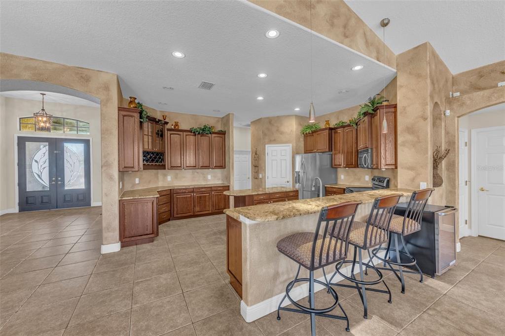 13101 Shadow Run Boulevard Riverview, FL 33569 - Photo 31 of 86 a kitchen with stainless steel appliances a sink a stove a refrigerator cabinets and chairs