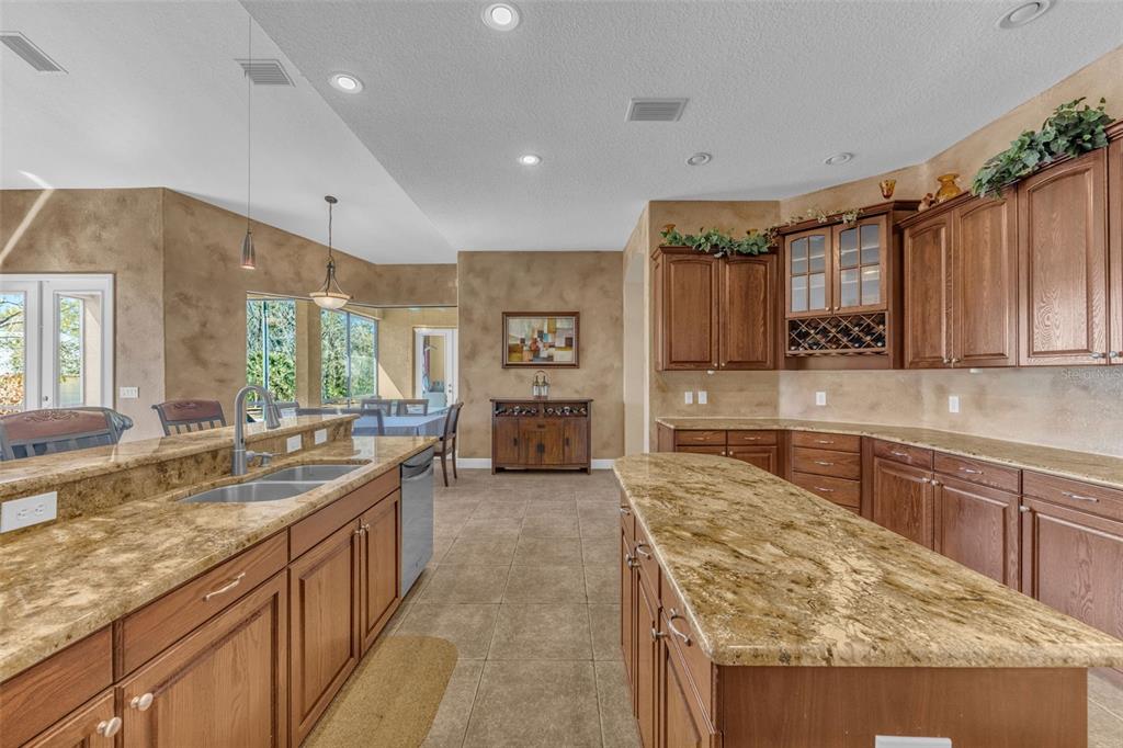 13101 Shadow Run Boulevard Riverview, FL 33569 - Photo 36 of 86 a large kitchen with kitchen island granite countertop a large counter top stainless steel appliances a sink cabinets and living room view
