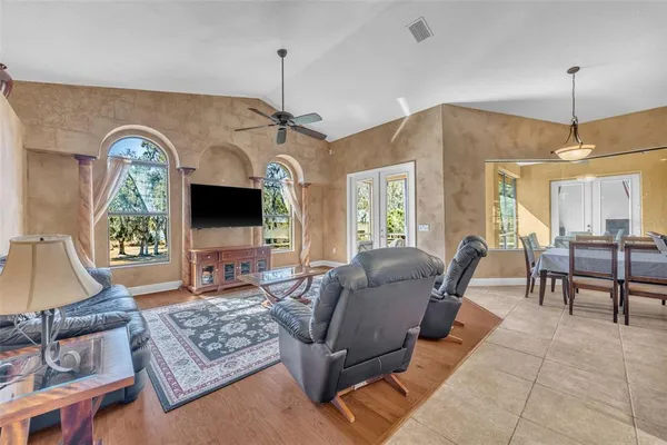 a living room with furniture a flat screen tv and a large window