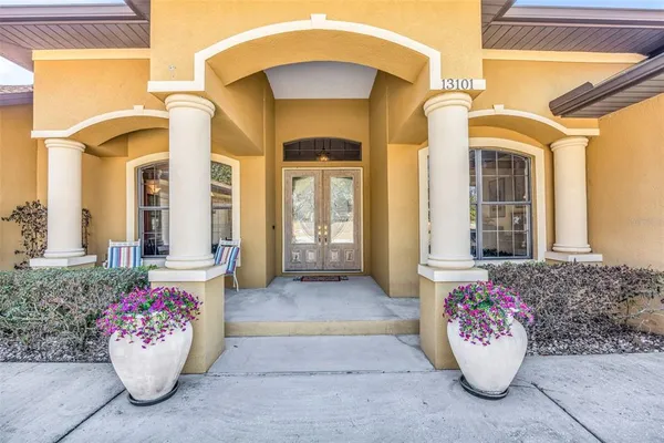 a dining room with furniture a chandelier and wooden floor