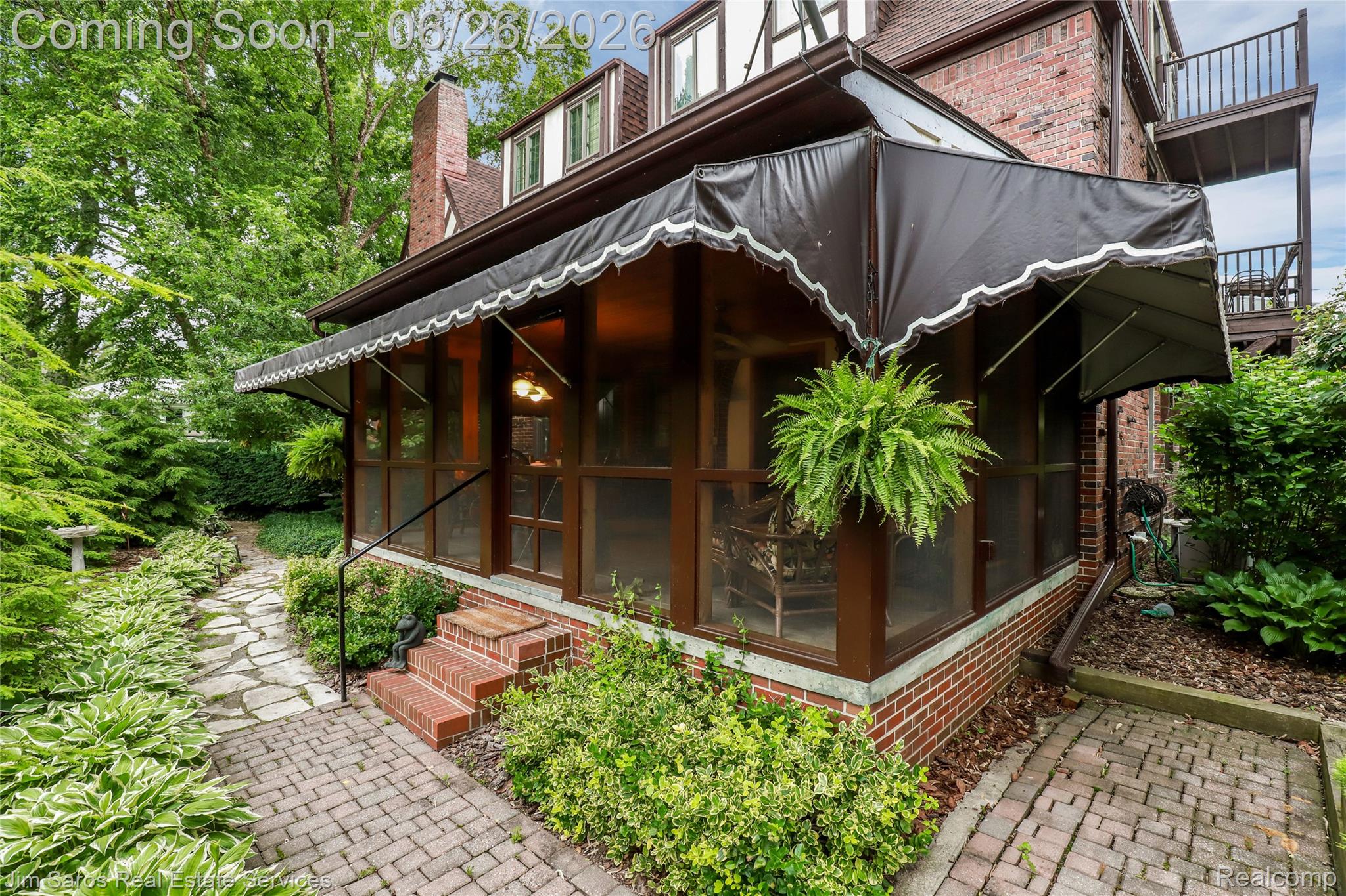 764 Harcourt Road Grosse Pointe, MI 48230 - Photo 39 of 42 Screened-in porch with a dark awning and white scallop trim, featuring brick steps and a metal handrail