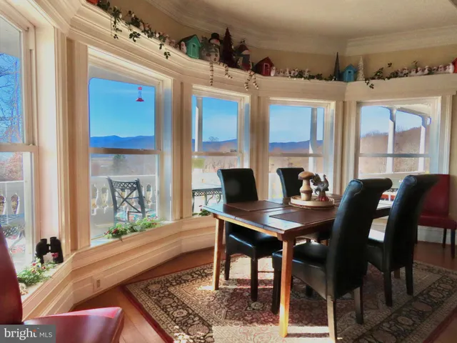 a bedroom with a bed a desk and chair with wooden floor