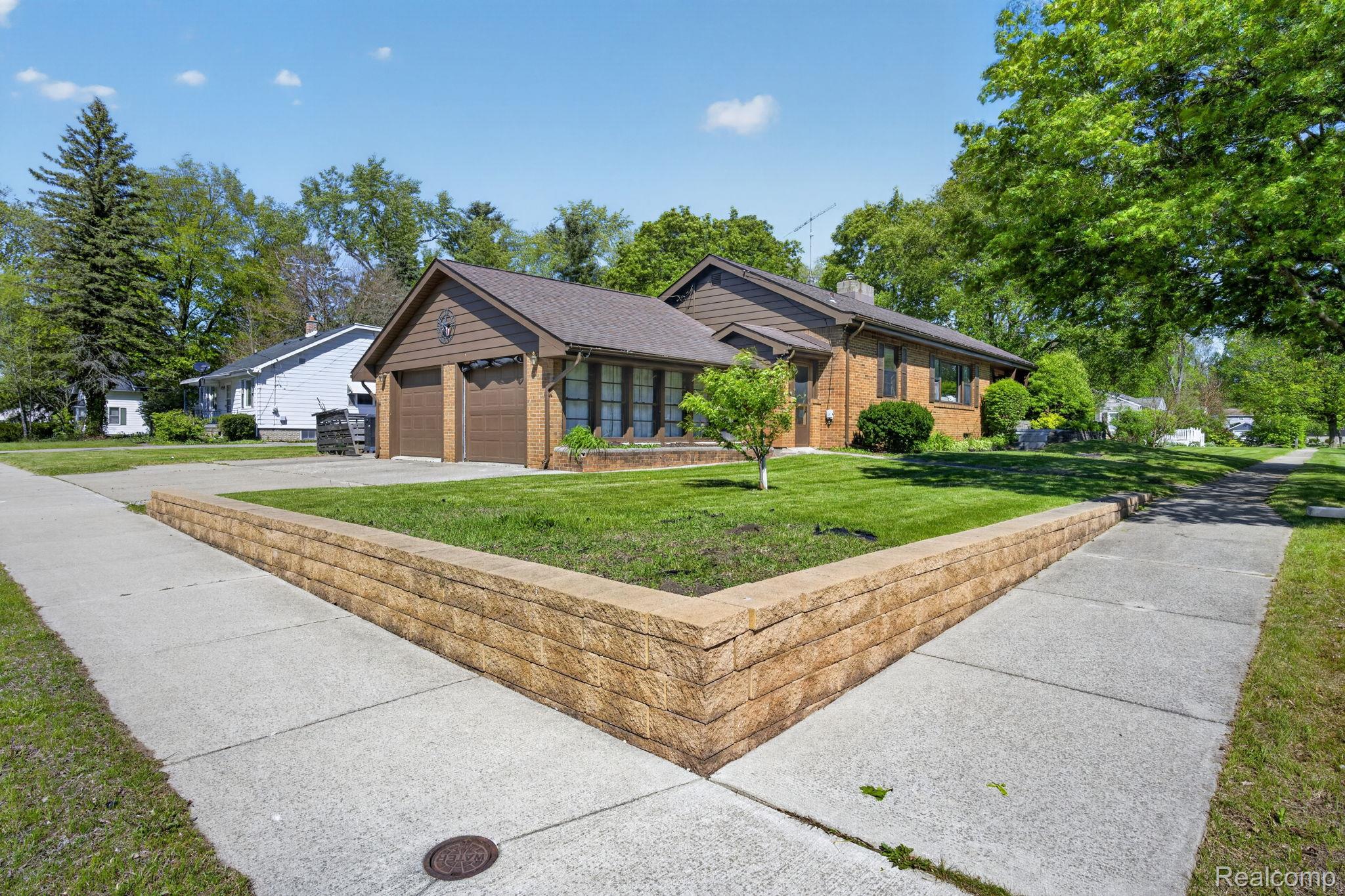 1209 Beatrice Street Flushing, MI 48433 - Photo 31 of 39 Ranch-style house with a front lawn, brick siding, concrete driveway, an attached garage, and a chimney