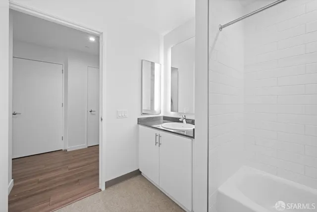 a bathroom with a granite countertop sink a mirror and a bathtub