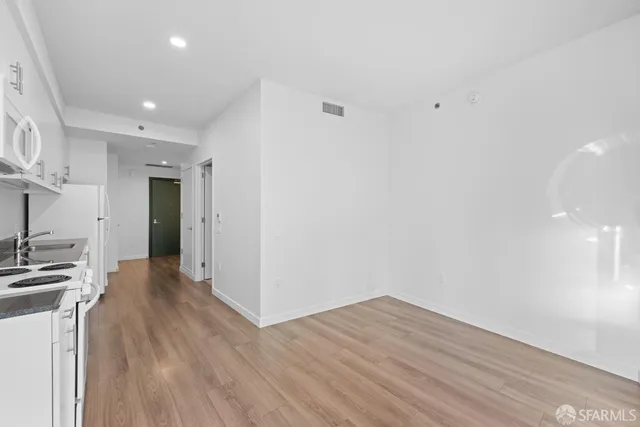 a view of a kitchen with wooden floor and a sink