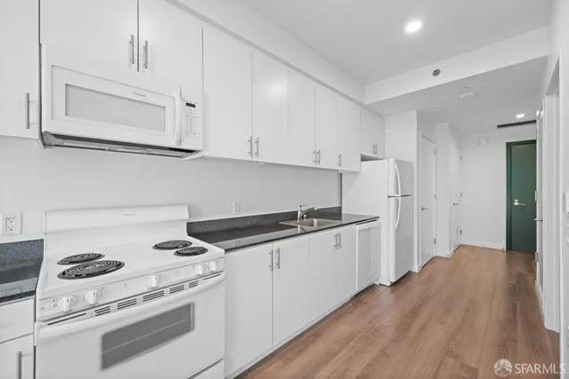 a kitchen with granite countertop cabinets and white appliances