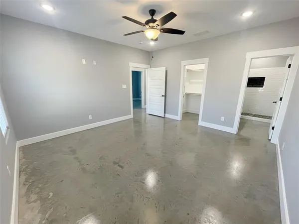 an empty room with closet and a ceiling fan