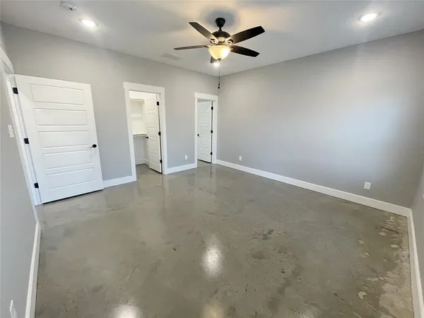 an empty room with a ceiling fan and a window