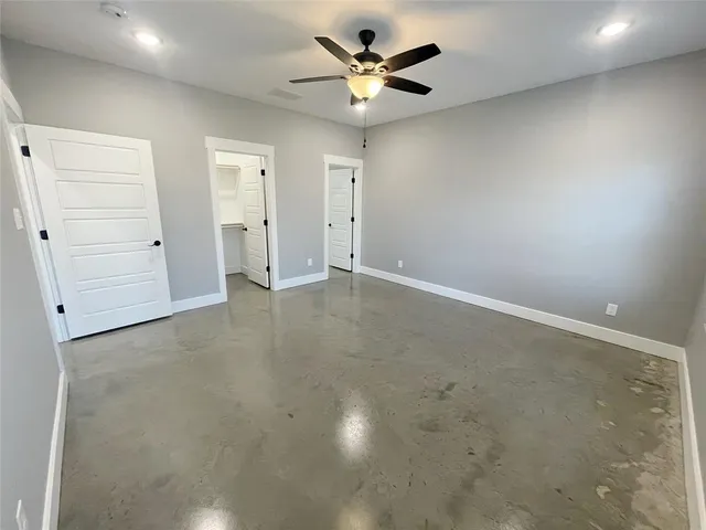 an empty room with a ceiling fan and a window