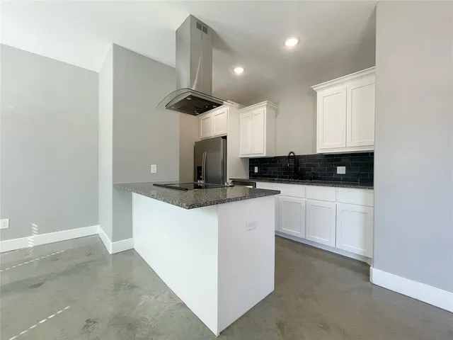 a kitchen with stainless steel appliances granite countertop a sink a stove and a refrigerator