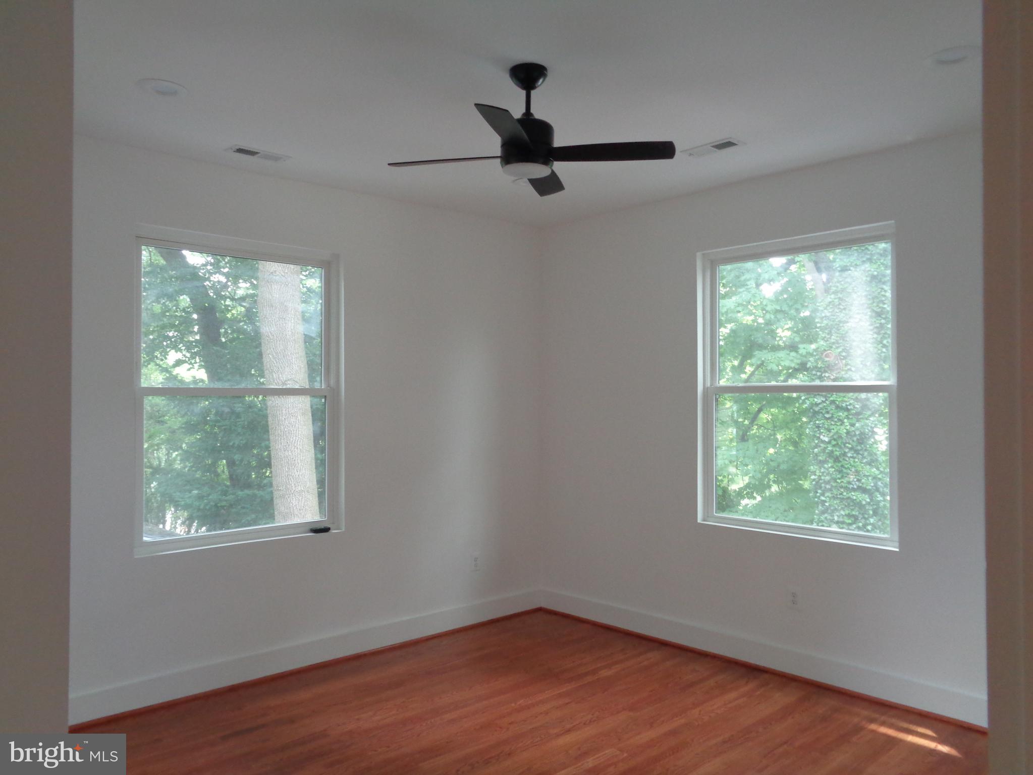 5105 Roland Avenue Baltimore, MD 21210 - Photo 13 of 19 en empty room with wooden floor fan and windows