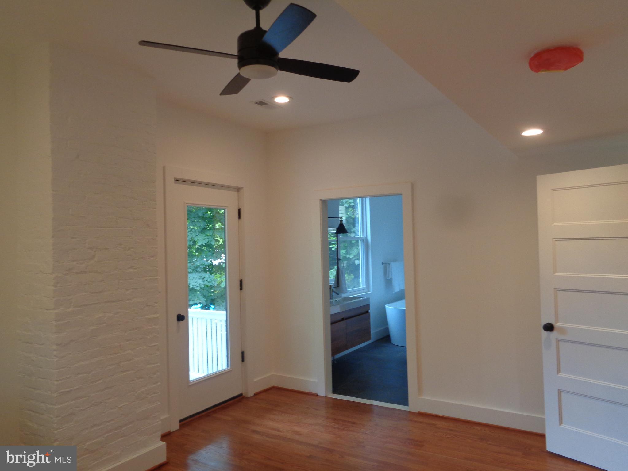 5105 Roland Avenue Baltimore, MD 21210 - Photo 14 of 19 an empty room with wooden floor fan and windows