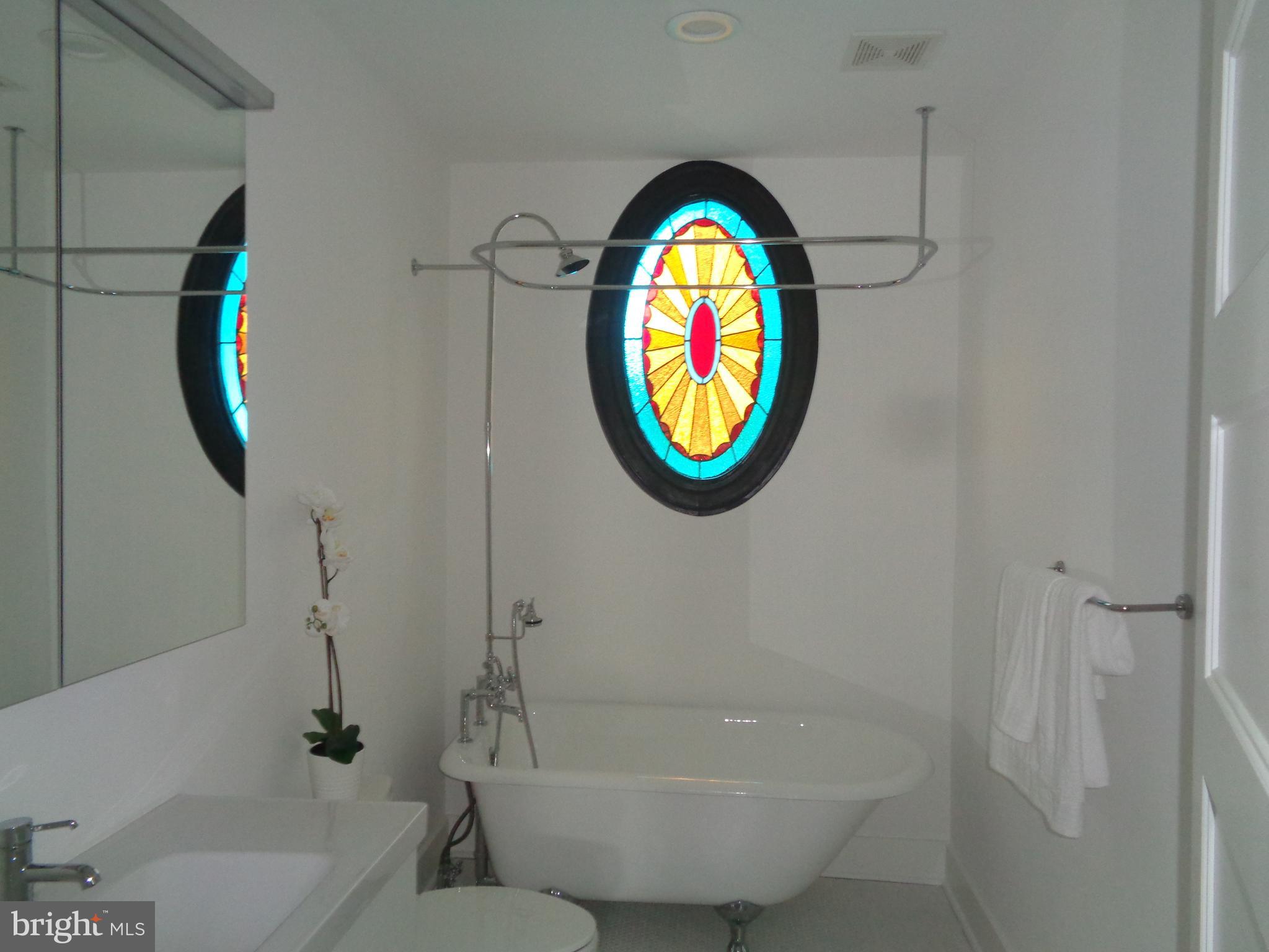 5105 Roland Avenue Baltimore, MD 21210 - Photo 15 of 19 a bathroom with a bathtub and mirror