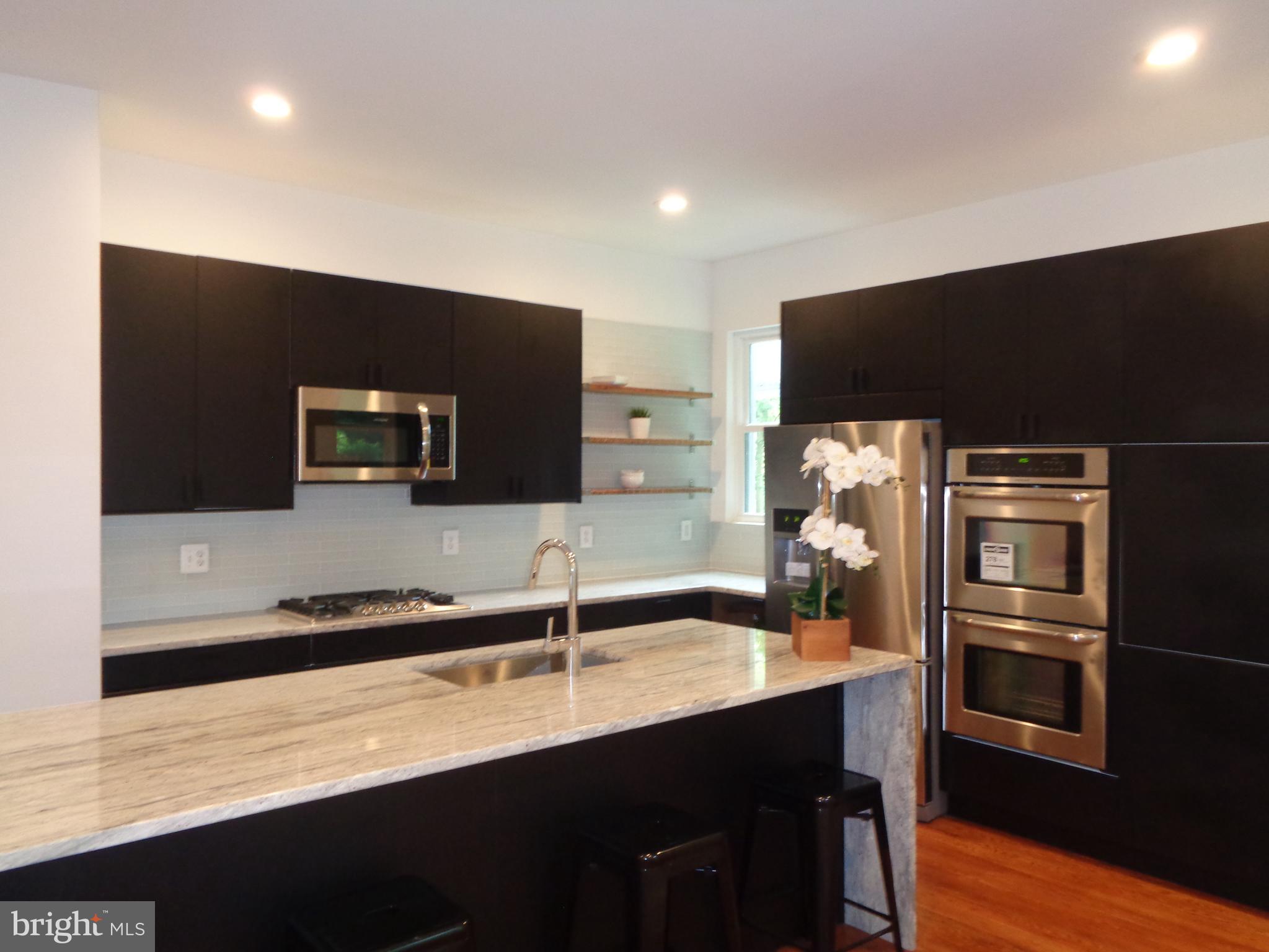 5105 Roland Avenue Baltimore, MD 21210 - Photo 3 of 19 a kitchen with stainless steel appliances a sink and a refrigerator