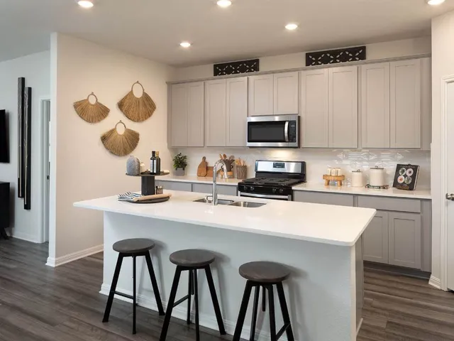 a kitchen with a sink cabinets and wooden floor